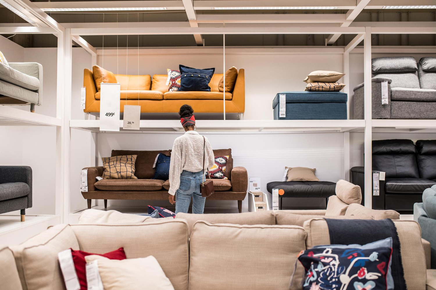 A shopper browsing sofas in a furniture showroom